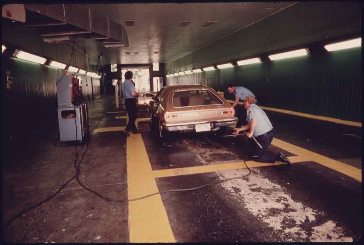 Inspectors test a car in the lane of a 1975 auto emission inspection station in Norwood, Ohio