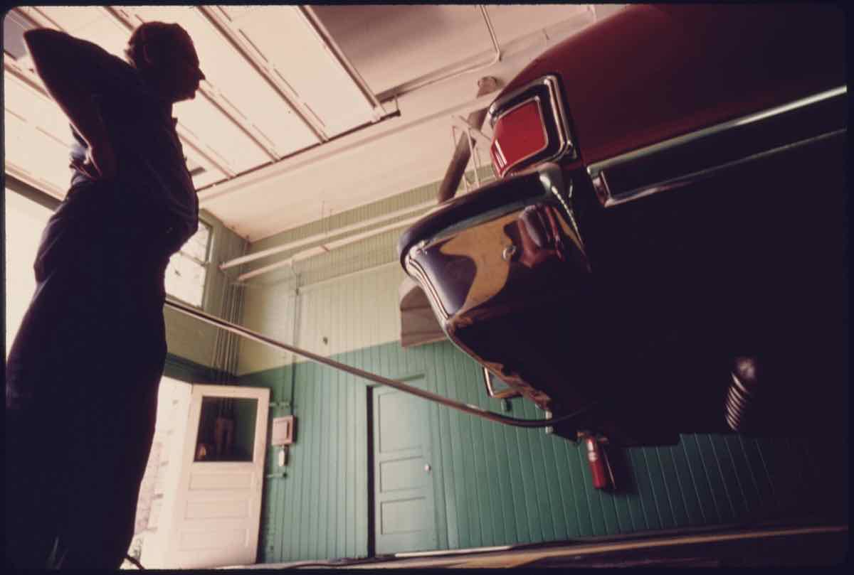 Exhaust probe in the tailpipe of a car during a 1975 emission test in Norwood, Ohio